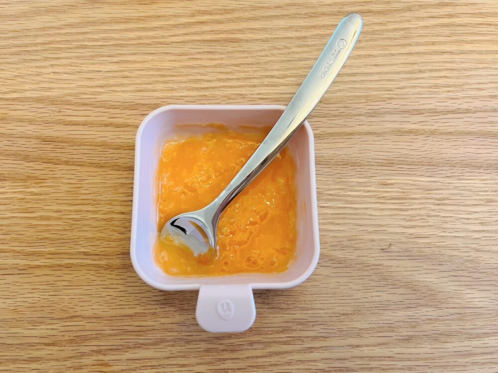離乳食初めてのにんじんミルク粥を小さじであげる様子