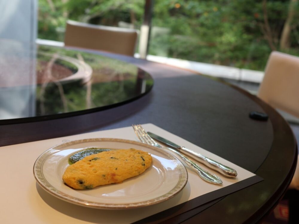 朝食のオムレツと窓から見える緑